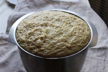 Yeast dough in a large glass bowl. Homemade cake. Concept of homework during the quarantine period.