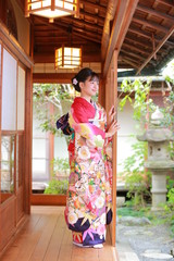 Fototapeta na wymiar Attractive girl wearing traditional japanese kimono in Japanese-style garden in kyoto, Japan.