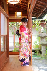 Attractive girl wearing traditional japanese kimono in Japanese-style garden in kyoto, Japan.