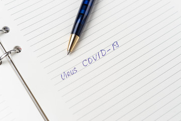 Coronavirus Covid-19 text written on empty sheet in a daily planner.