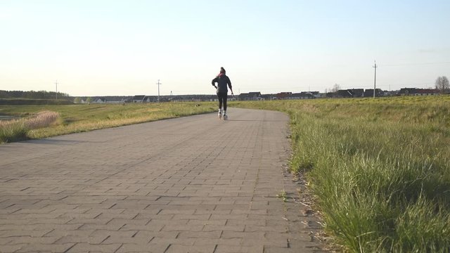 Training an athlete on the roller skaters. Biathlon ride on the roller skis , in the helmet. Autumn workout. Roller sport. 