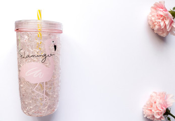 Summer flat lay. Summer background. The cocktail glass is on a white background. Pink flowers. Pink Flamingo.