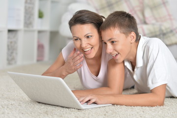 Portrait of mother and son using laptop
