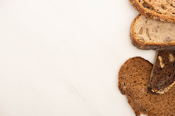 top view of fresh whole grain bread slices on white background with copy space