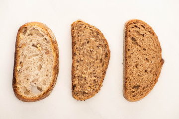flat lay with fresh whole grain bread slices on white background