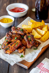 Pork ribs with potatoes on a wooden background. Barbecue. Grill. American cuisine. Recipe.