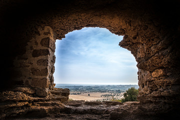 View on the coast through the hole of an ancient wall