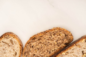 top view of fresh brown bread slices on white background