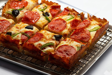 sliced detroit pizza on an iron tray