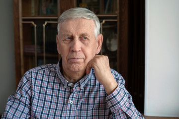 Portrait of a serious, pensive old man, 80 years old.