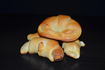 Homemade pastry. Bagel, сroissants on a dark background.