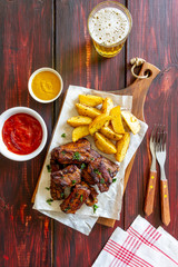 Pork ribs with potatoes on a wooden background. Barbecue. Grill. American cuisine. Recipe.