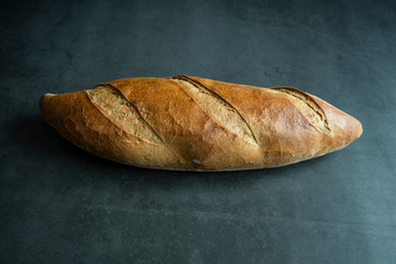 Fresh baked loaf bread on concrete background. Healthy, delicious and homemade food.