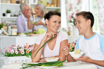 Portrait of mother and son eating at kitchen