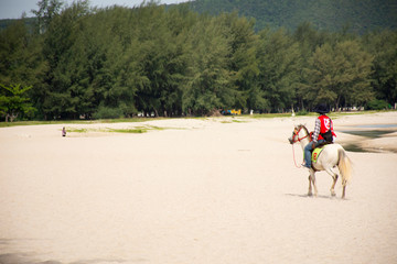 Thai people cowboy riding horse on beach waiting foreigner travelers use service ride horse walk tour at Samila Beach on August 17, 2019 in Songkhla, Thailand