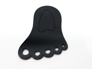Foot shaped black rubber door wedge isolated on white background. Original aerial view of Black door rubber bracket.