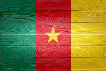 Cameroon flag painted on old wood plank background. Brushed natural light knotted wooden board texture. Wooden texture background flag of Cameroon.