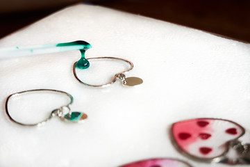 Pouring glitter green resin to heart shaped earrings , process of prepare for make an accessories