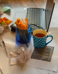 Quarantine home office - charts, crumpled paper, snack and laptop