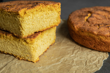 Freshly baked sliced and unsliced corn bread on baking paper. Delicious, organic and healthy homemade food.