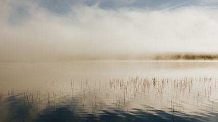 Brume sur le lac et effet miroir au lever du soleil 