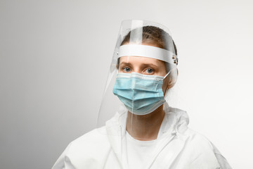 Fototapeta na wymiar young woman in medical mask and protective shield on her head