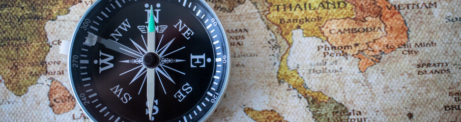 Compass on vintage map using as background business travel cover page concept.
