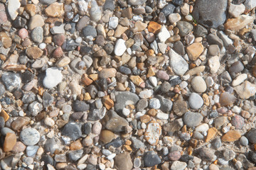 Hintergrund - bunte kleine Kiesel am Strand, feine Steine und Sand