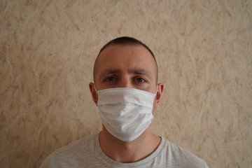 
a man in a medical mask is standing on the wall of a house