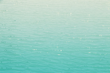 Green water waves reflecting sunlight