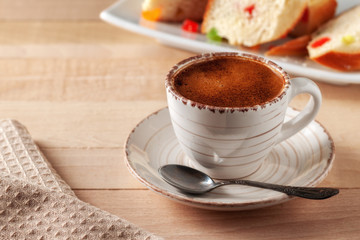 Cup of fresh aromatic coffee with homemade cakes on a wooden table