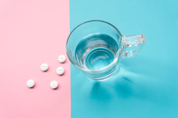pills on turquoise and pink background for the prevention, immunization and treatment of coronavirus infection (new coronavirus disease 2019, COVID-19, nCoV 2019 from Wuhan).