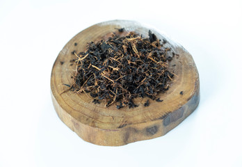 Dry black tea leaf in wooden platter on white background. Traditional, healthy and organic beverage.