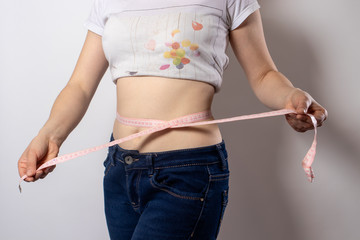 Measurement of the waist with a centimeter tape. Weight loss through proper nutrition, keto diets....