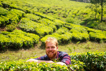 Naklejka na ściany i meble redhaired ginger male enjoying morning in India chai plantations Munnar