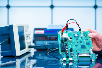 Debugging electronics device. PCB witch microcontroller in electronics laboratory