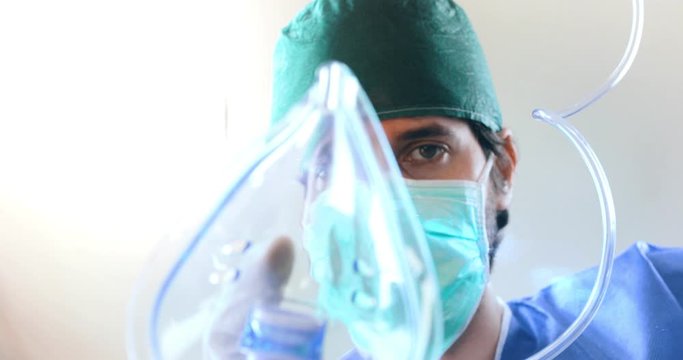 Punto di vista di un paziente mentre viene intubato con la mascherina di ossigeno da un dottore in sala operatoria durante il Coronavirus.