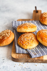 bun buns with sesame seeds on a wooden board.