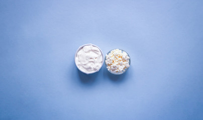 Selective focus to fresh cottage cheese and homemade sour cream in the bowl on a table. Copy space....