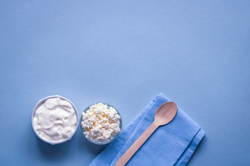 Selective focus to fresh cottage cheese and homemade sour cream in the bowl on a table. Copy space. Top view.