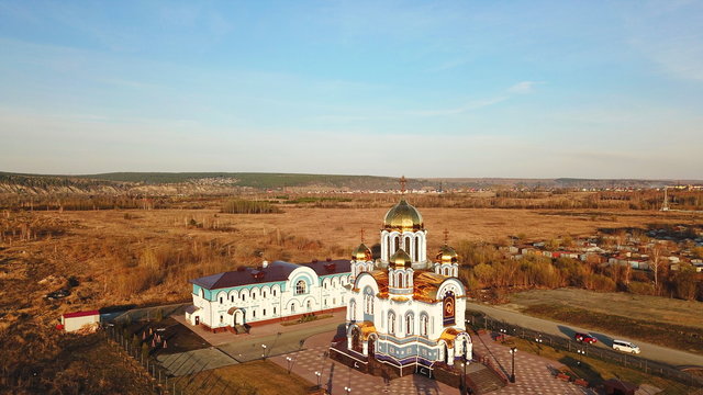 cathedral with golden domes and white walls, Kemerovo, shot from the drone.