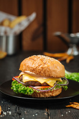 Tasty cheeseburger on a dark wooden background