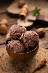 Bowl of chocolate and hazelnut ice cream on wooden table