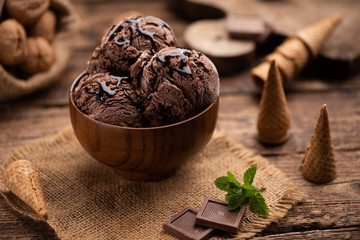 Bowl of chocolate and hazelnut ice cream on wooden table