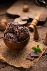 Bowl of chocolate and hazelnut ice cream on wooden table
