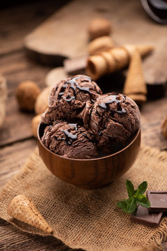 Bowl of chocolate and hazelnut ice cream on wooden table