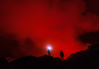 Two tourists with the headlights at the edge of Nyiragongo volcano