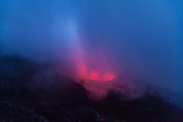 Fototapeta na wymiar Smoke above the lava lake glowing red
