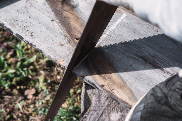 to cut wooden planks, chainsaw sawing a piece of wood, a worker works and sawing branches