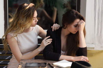 A friend calms a distressed friend because of a recent setback.